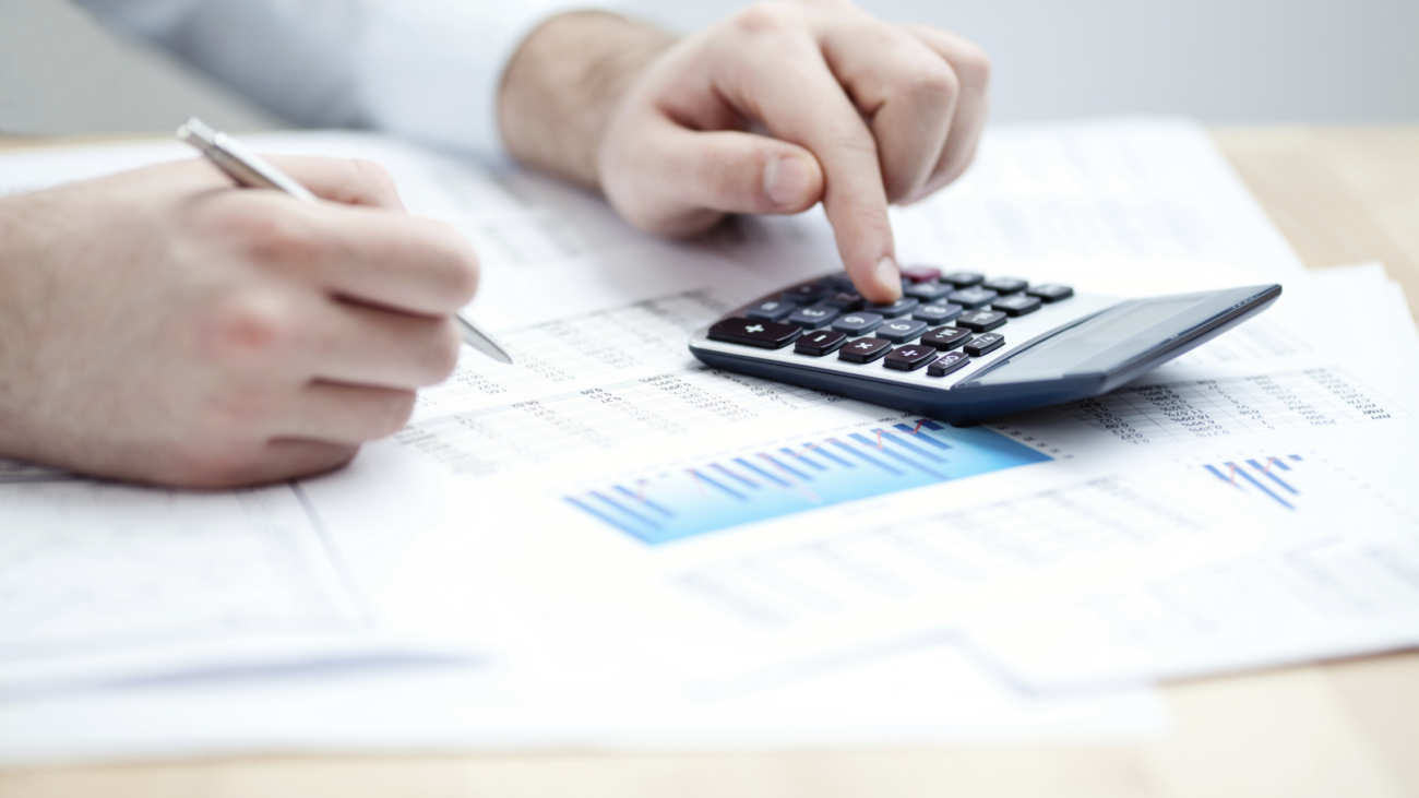Financial data analyzing. Counting on calculator.